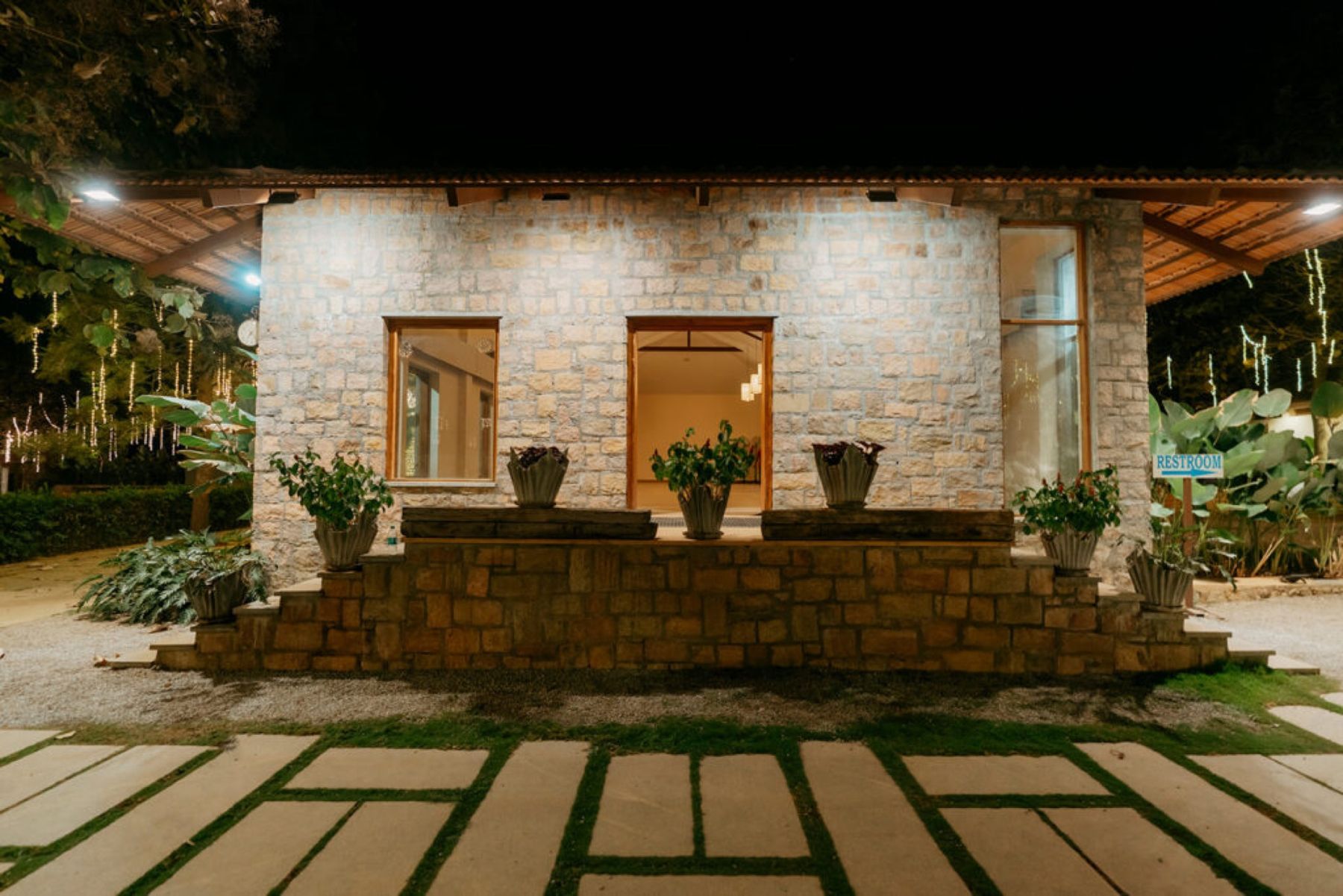 A stone cottage lit at night